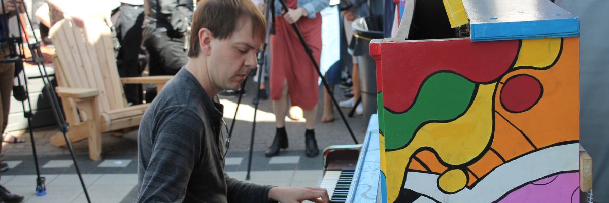 A musician playing an outdoor piano
