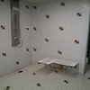 An accessible shower station equipped with hand rails and seating at the John Rhodes Community Centre.