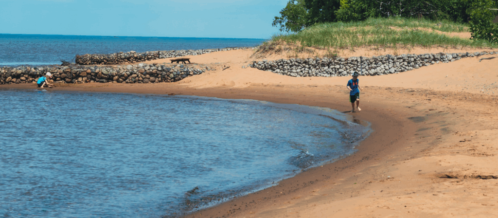 2 children play on Pointe Des Chenes beach