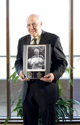 Tony Celi posing with plaque for Sports Hall of Fame