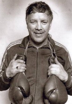 Frank Nolan Sr. smiling with boxing gloves around his neck