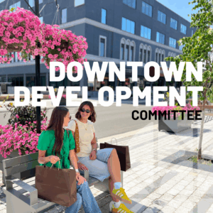 Downtown Development Committee. Picture of two girls sitting on a bench on Queen Street in downtown Sault Ste. Marie with shopping bags.