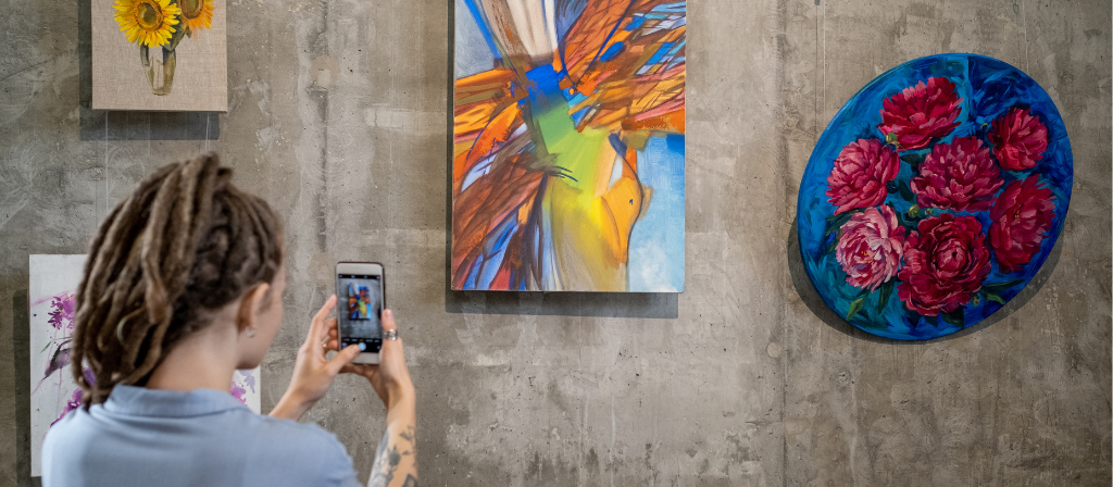 photo of a student with art taking a photo on a cellphone